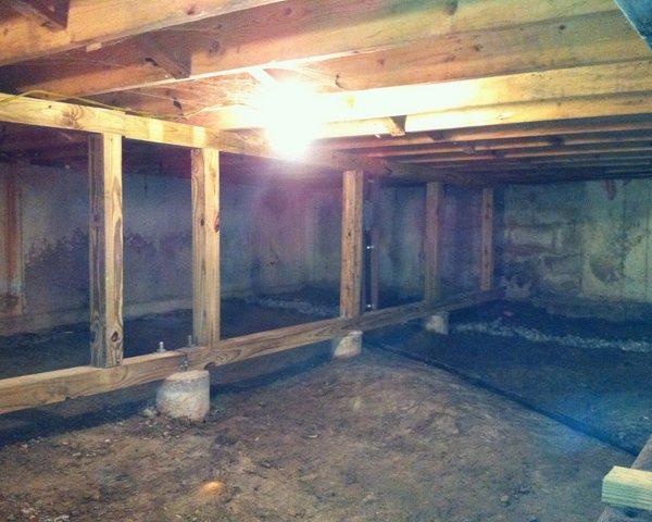 This Colebrook, CT crawl space was very wet, with water seeping in through the walls and dirt floor. To seal it off and make it a dry space, we installed our CleanSpace crawl space encapsulation system. Beneath the plastic liner, we installed our drainage matting. Its raised dimples provide a channel for water to leave the crawl space, so it does not get trapped beneath the liner. 