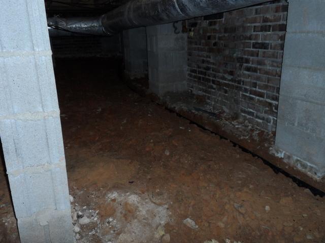 The photo here shows the drainage pipe. We make a deep trench in the crawlspace floor and embed the pipe.