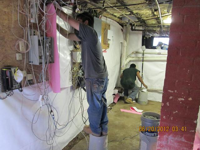 The laborers installing the BrightWall on the interior basement wall