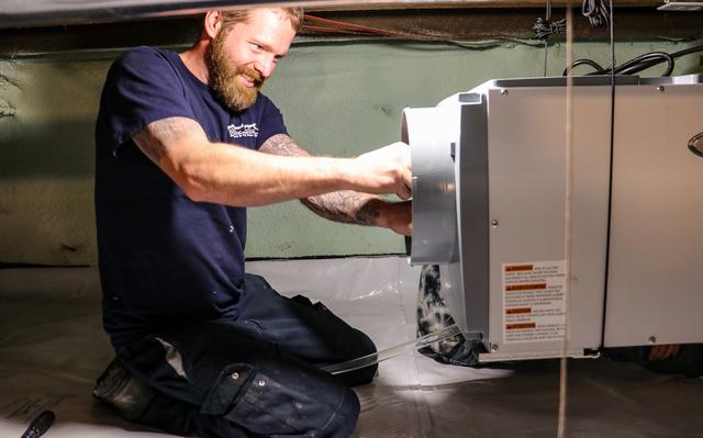 Foreman, Justin Fysh installs our hanging kit for our Aprilaire dehumidifier system.