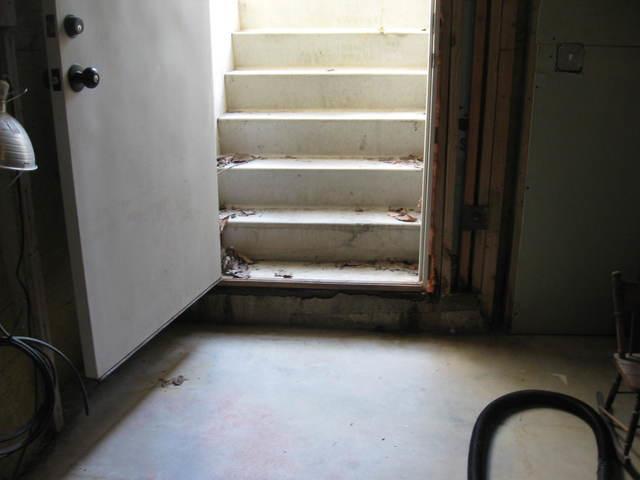 The hatchway stairs leading to this Norfolk, CT basement were leaky. They allowed water to enter the basement. To prevent this, we installed a trench drain at the base of the stairs. Its open grate collects any water that would enter the basement. The trench drain is connected to the perimeter drainage system, and water is directed out of the basement through that, keeping it dry for the homeowners to enjoy.