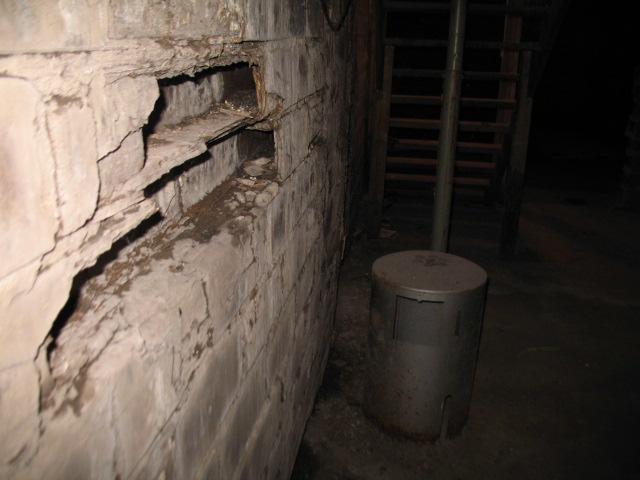 <p>Pieces of a foundation wall falling onto the floor leaving a gaping hole in the foundation wall.&nbsp;</p>