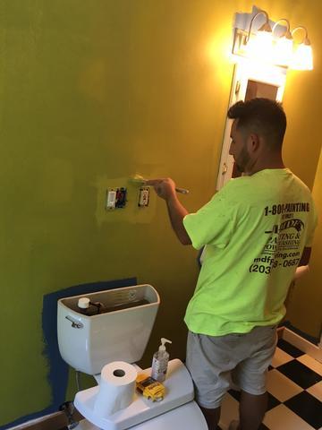 This painter is outlining the wall sockets to avoid any paint splatter.