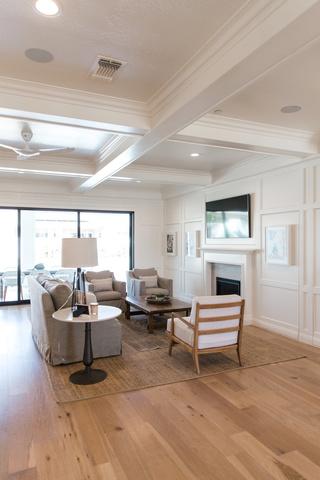 This photo displays additional view of the coffered ceilings and wainscoting as well as the natural hardwood floors.