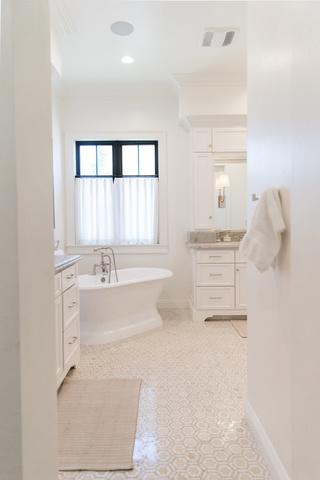 Beautiful stand alone tub and subtle white and cream tile design.