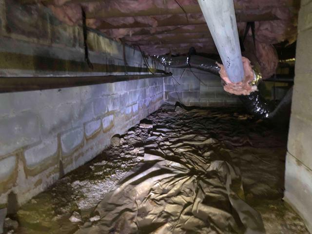 Staining along the walls is evidence that this crawl space sees a lot of water when it rains, contributing to the dampness in the crawl space and in the home. The existing vapor barrier is not covering the ground completely, nor is it sealed preventing vapor from getting into the crawl space.