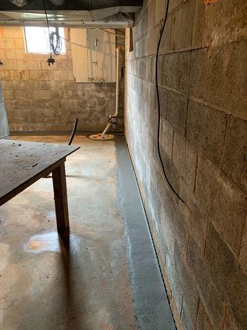 Once wet and now dry, this basement is prepared to take any water that makes it way into the block walls and pump it out away from the home through a sump pump.