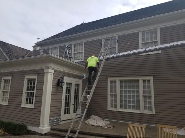 Painter climbs ladder to add fresh paint.