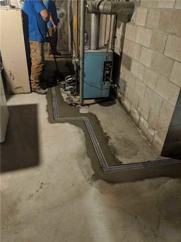 With devices in the basement that might leak or are tough to get around we use TrenchDrain that links with the rest of the drainage and collects water that could flow over it.