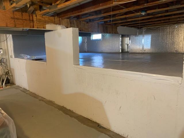 Crawlspace with SilverGlo insulation installed and WaterGuard installed on the basement wall.