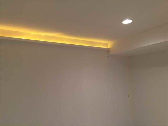 With the walls put in place, our crew was also able to implement this very unique lighting scheme that has yellow light leaking out of the top of one side of the basement walls. Another very unique installation that adds ambiance and originality to this Riverside basement.