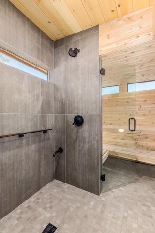 The shower has multiple showering heads to allow for more than one person to shower at the same time. The faucets are Kohler Purist. The shower also has a seamless entry from the steam room to the shower. The floor tile is Reside Ash from Arizona Tile.