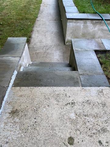 Mildew and dirt are cleaned off the walkways after pressure washing.