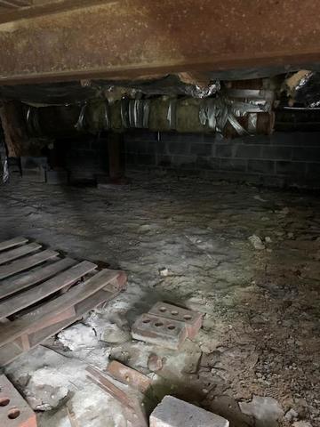 <p>Dirt floor, sagging fiberglass insulation supported by duct tape.</p>