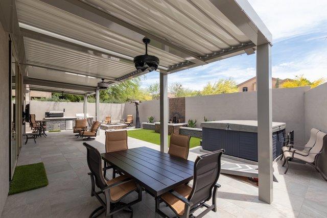 Really, it's like a resort back here. You have the hot tub, the grills, the fire pit, plenty of tables and chairs and a very beautiful, comfortable space to be. The louvered ceiling is closed here.