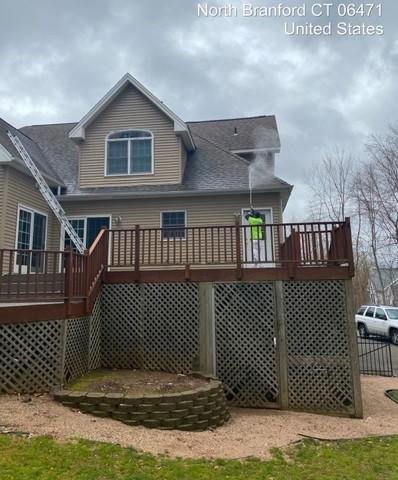 Power washing technician cleans the home and deck before adding new stain.