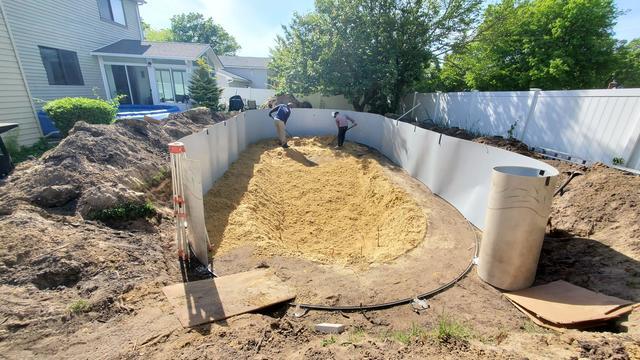 Sand is laid as the base for the pool and the pool walls begin to go up