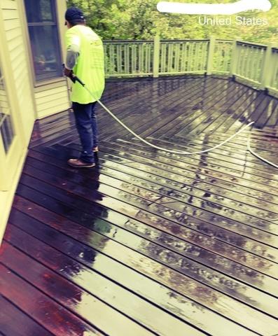 Prepping for deck staining by power washing away the dirt.