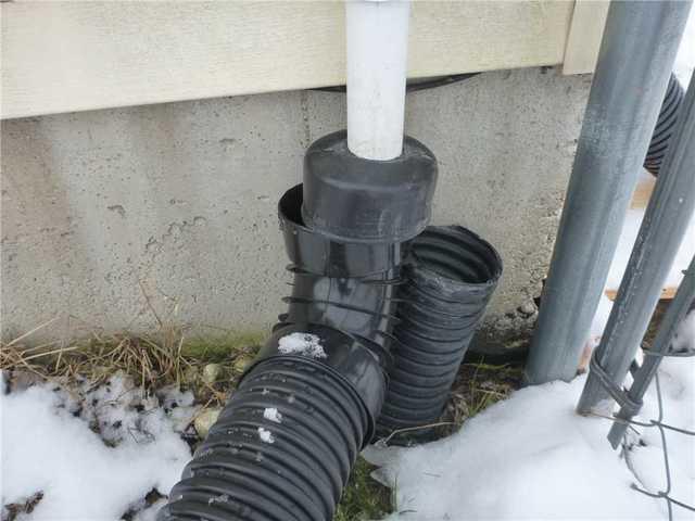 This plastic discharge line is above ground and susceptible to frigid temperatures. Frozen lines do not allow water to leave the home and bypass the frozen blocks of ice built up inside the pipes.