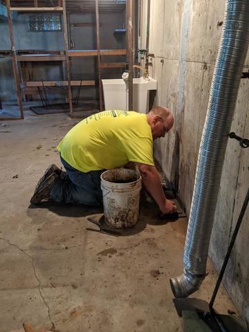 Concrete over the drain will keep water from reentering the basement.