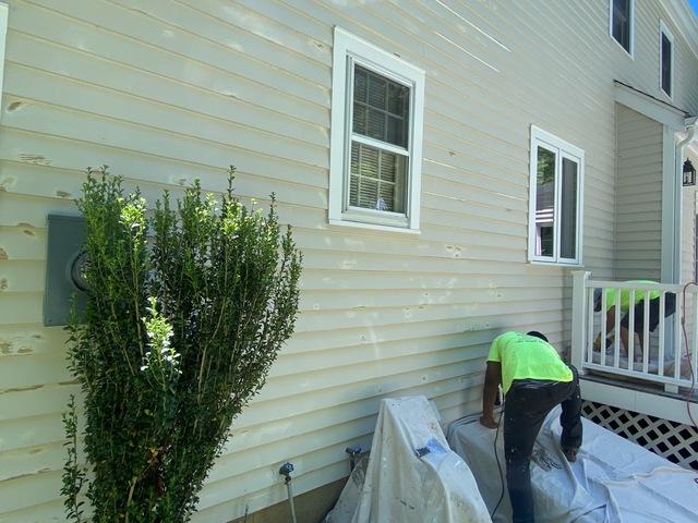 Painters appyling primer after sanding down the peeling paint.