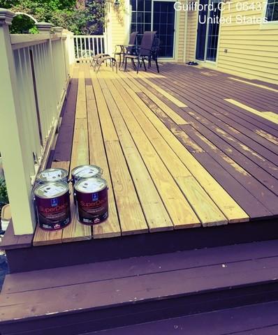 Deck floor boards are sanded down to prep for new stain.