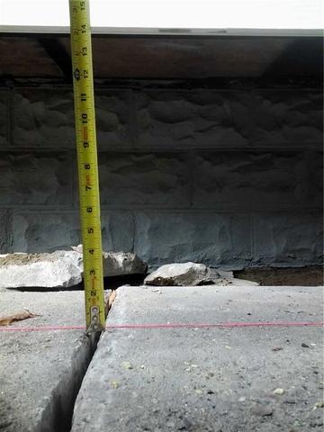 <p>When the slabs in this Burlington driveway started sinking, separations like this one caused people to trip and fall.</p>