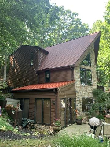 Back view of home with the new asphalt shingles installed as well as the standing seam metal panels installed on the Florida room.