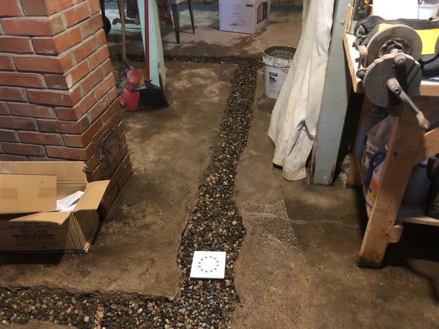 After the french drain system is put in place, aggregate rock is place around the drain for better drainage when moisture accumulates below the surface of the concrete.