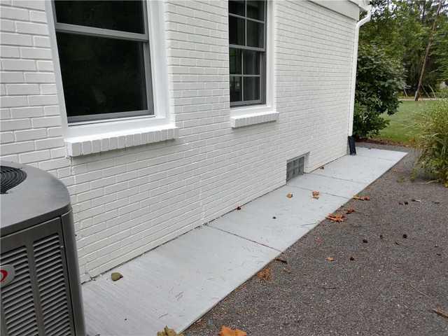 This a view from the outside of the home. You can see by the first window that there are cracks in the brick. These cracks are due to the settling of the foundation wall.