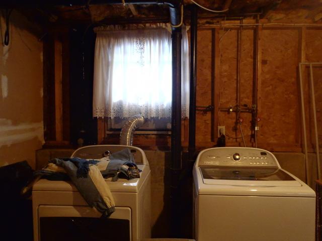 Unattractive and uninviting laundry space. 