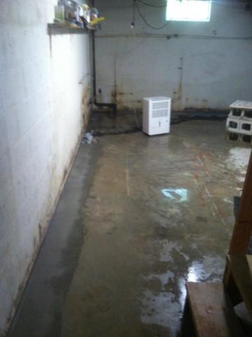 <p>Here is a photo of the repair of the front and side wall of the Fort Knox basement. You will see where the floor is wet from us cleaning and water testing the system to ensure everything is working properly. This also allowed the installation team to have a cleaner surface to pour concrete the following morning.&nbsp;</p>