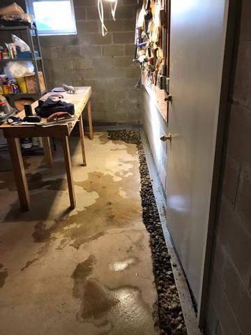 Our team cut out the concrete floor perimeter by forming a trench, installed our WaterGuard System, and filled the open gaps with river rock.