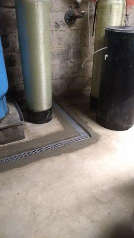 The TrenchDrain has a grated opening which accepts water from the floor, where it's then redirected to the perimeter drain and sump pump.