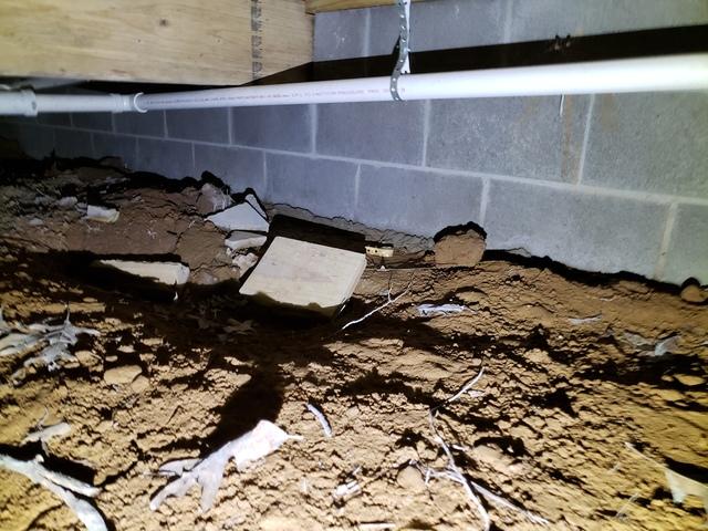 This is what the crawl space looked like before our crew got in there and cleaned everything out.  After everything is cleaned out the ground is leveled to prepare for the drainage matting.