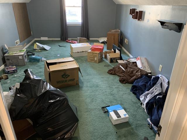 Before - Clothes, boxes, and linens to be removed.