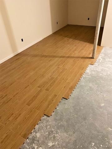 This flooring has the look of wood but is engineered to resistant water damage and mildew growth. Additionally, its designed to provide a thermal break from the concrete, giving floors a temperature increase of 10 degrees.