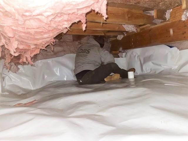 DBS Crew Member Secures Vapor Barrier