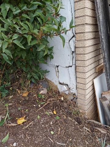 Pictured here is the outer wall of the garage where cracking and shifting is evident. Because this corner has been settling for a few years, symptoms are developing in the living space above the garage as well.