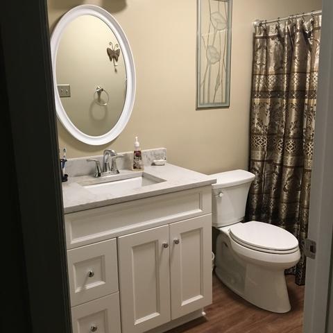 View of a new vanity, mirror, and toilet