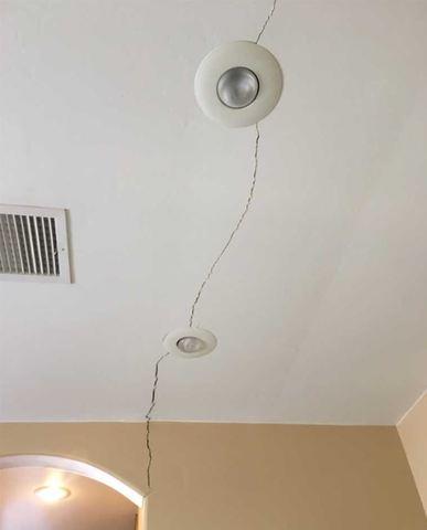 Sometimes, a wall crack will extend into the ceiling (as is the case here).  Wall cracks and ceiling cracks are symptoms of a foundation issue.