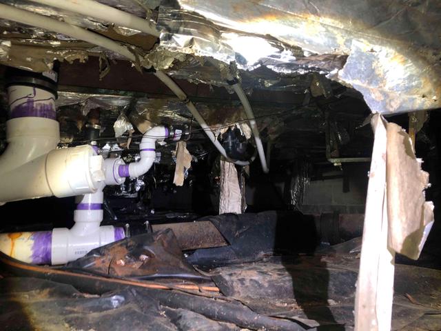 The vapor barrier of this crawl space has been pushed aside and ripped in multiple places, exposing the dirt flooring. The earth's moisture rises from the earth/ground/soil and raises the relative humidity, which can lead to mold and mildew growth, condensation, and water puddles.