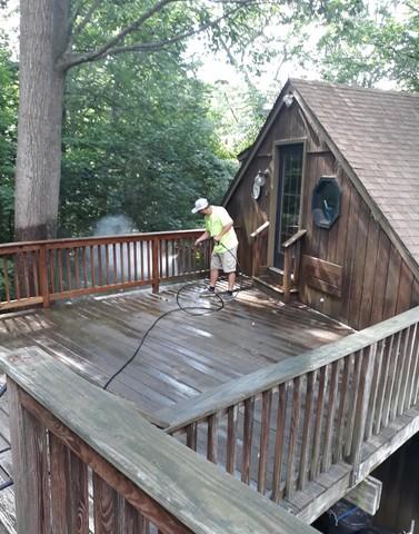 A team member power washing the surface.