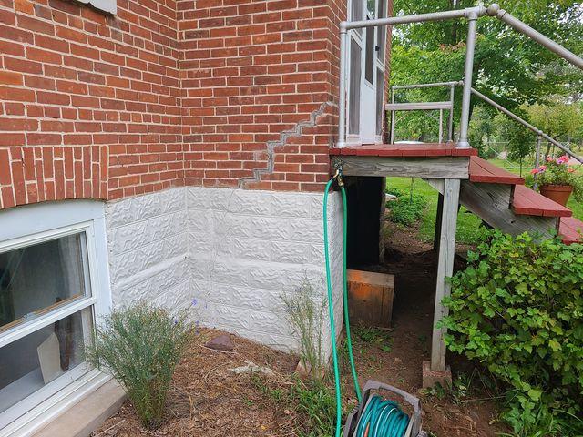 Forces of nature caused this foundation to slowly settling, cause the stair-step cracks seen here.