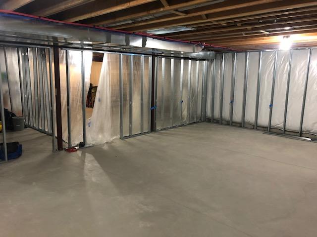 <p>Early in the installation process, you can see the framework for the EverLast Wall Panels has been installed around the exterior of the finished area of the basement as well as to divide the basement into finished and unfinished halves.</p>