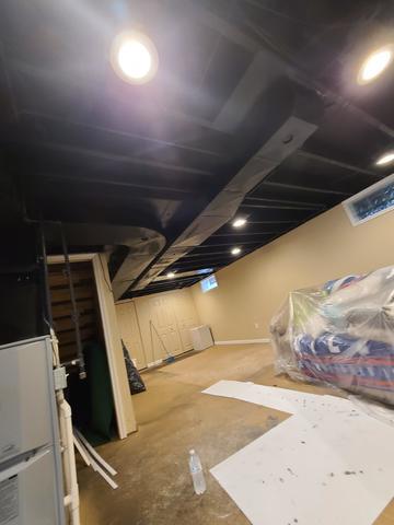 <p>The basement ceiling has been painted black and the lights reinstalled. Even though it is dark it looks clean and adds depth to the space.</p>