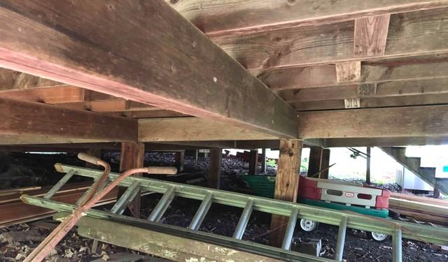 Wooden Supports Leaning Beneath the Crawl Space