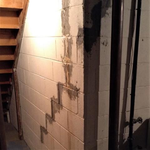 The block foundation wall was covered in leaking stair-step cracks that needed to be filled and stabilize to prevent them from worsening.