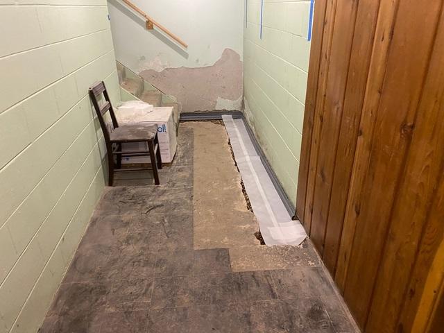 The WaterGuard is a French drain that goes around the perimeter of the basement to collect the water that seeps in. It is under the stairs and through the wall as you can see to make sure no water gets in your basement.