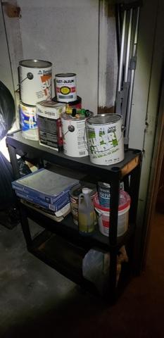 Cans of paint on a cart.